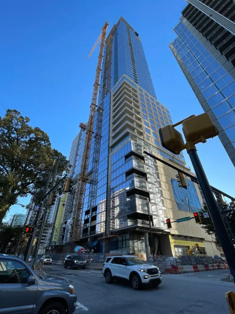 Ground view of skyscraper made of concrete and glass in front of a blue sky