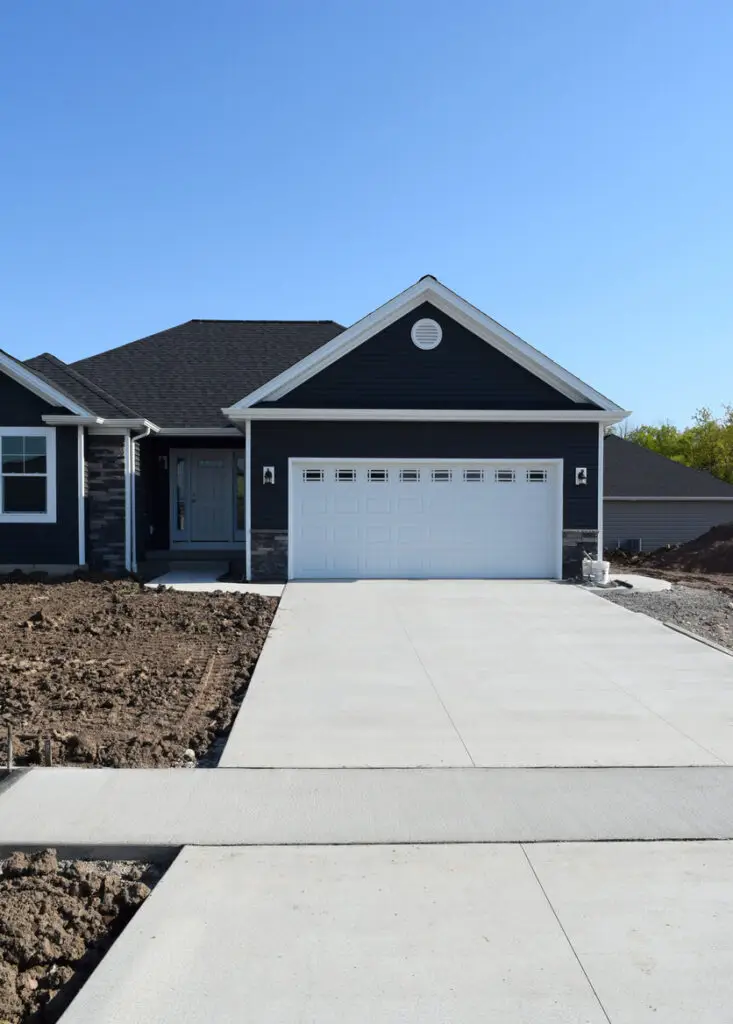 A one-story home with freshly paved driveway.